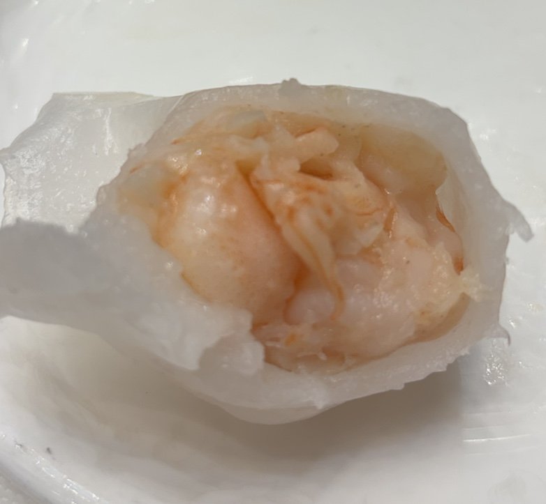 Steamed seafood dishes beside tea cups.